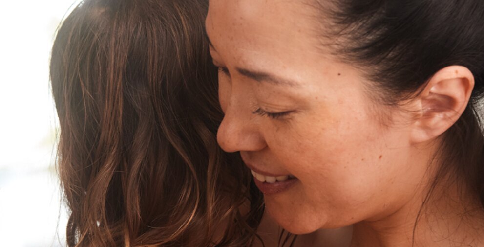 close-up van een glimlachende vrouw die een kind omhelst