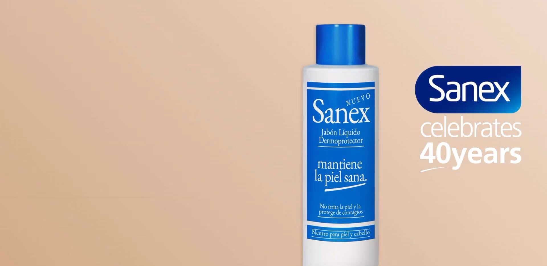 Fles Sanex vloeibare zeep met blauwe dop op een beige achtergrond, met het Sanex-logo en de tekst "celebrates 40 years" aan de rechterkant.